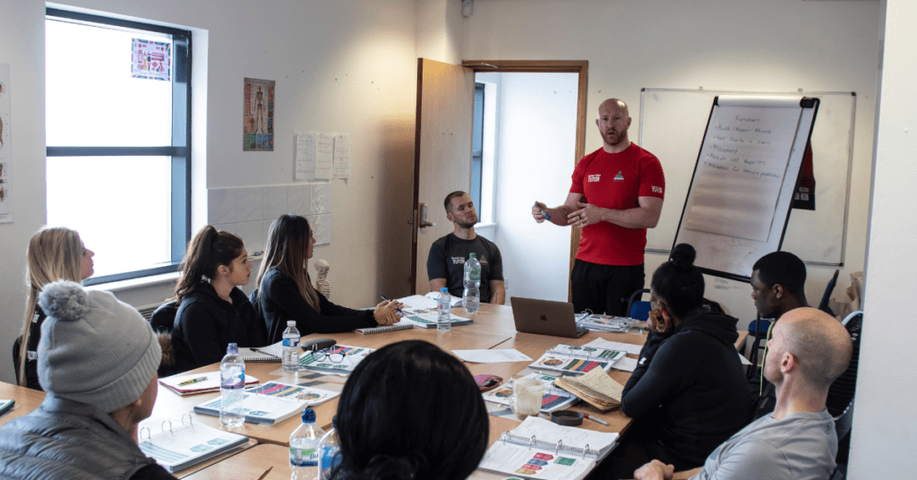A personal trainer leading a course in a classroom.